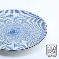 藍染千段十草八吋圓盤，盤面以深藍色線條勾勒出放射狀的「千段」與「十草」紋樣，中心點缀同色圓形，陶瓷材質，邊緣帶有細微棕色線條。