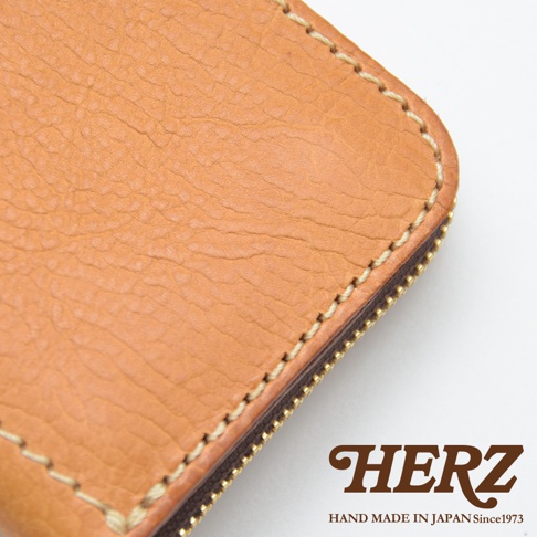 職人手作皮革經典拉鍊長夾 WL-58 淺棕色。特寫鏡頭展示了皮革表面自然紋理、手工縫線細節與金色拉鍊。