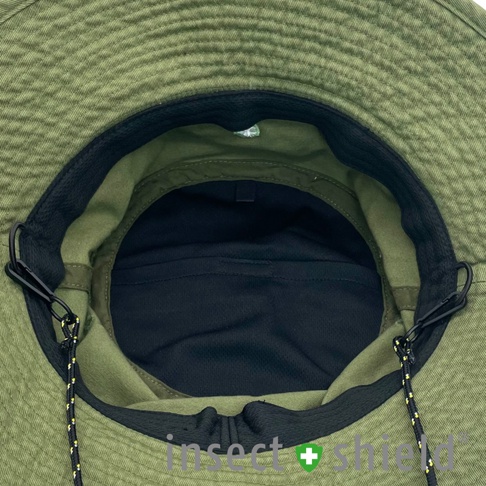 頂部視角展示的軍綠色兒童機能防護帽，帽簷外側有紋理，內裡結構清晰，包括黑色透氣網布及可調整的繫繩，兩側設有黑色夾扣。