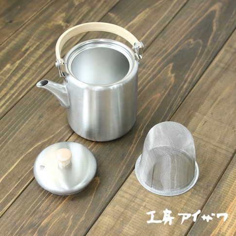 霧面不鏽鋼直筒茶壺，附有木質上弦把手，壺身為圓柱形，帶有細長壺嘴。另有同材質壺蓋及濾網。