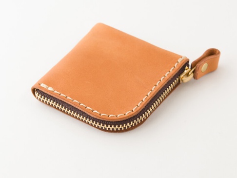 職人手作皮革分隔收納零錢包，淺棕色牛皮材質，搭配咖啡色縫線和黃銅色拉鍊，簡約方形設計，一側有皮革拉環。