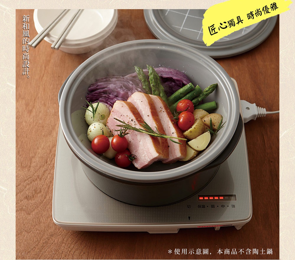 深灰色陶土蒸盤內盛有蒸煮的培根、紫甘藍、蘆筍、小番茄、馬鈴薯塊及小洋蔥，置於白色加熱底座上，底座顯示加熱指示燈，整體呈現烹飪的畫面。