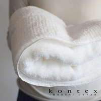 一條白色極柔蓬鬆的今治毛巾，質地細緻，邊緣有縫線。