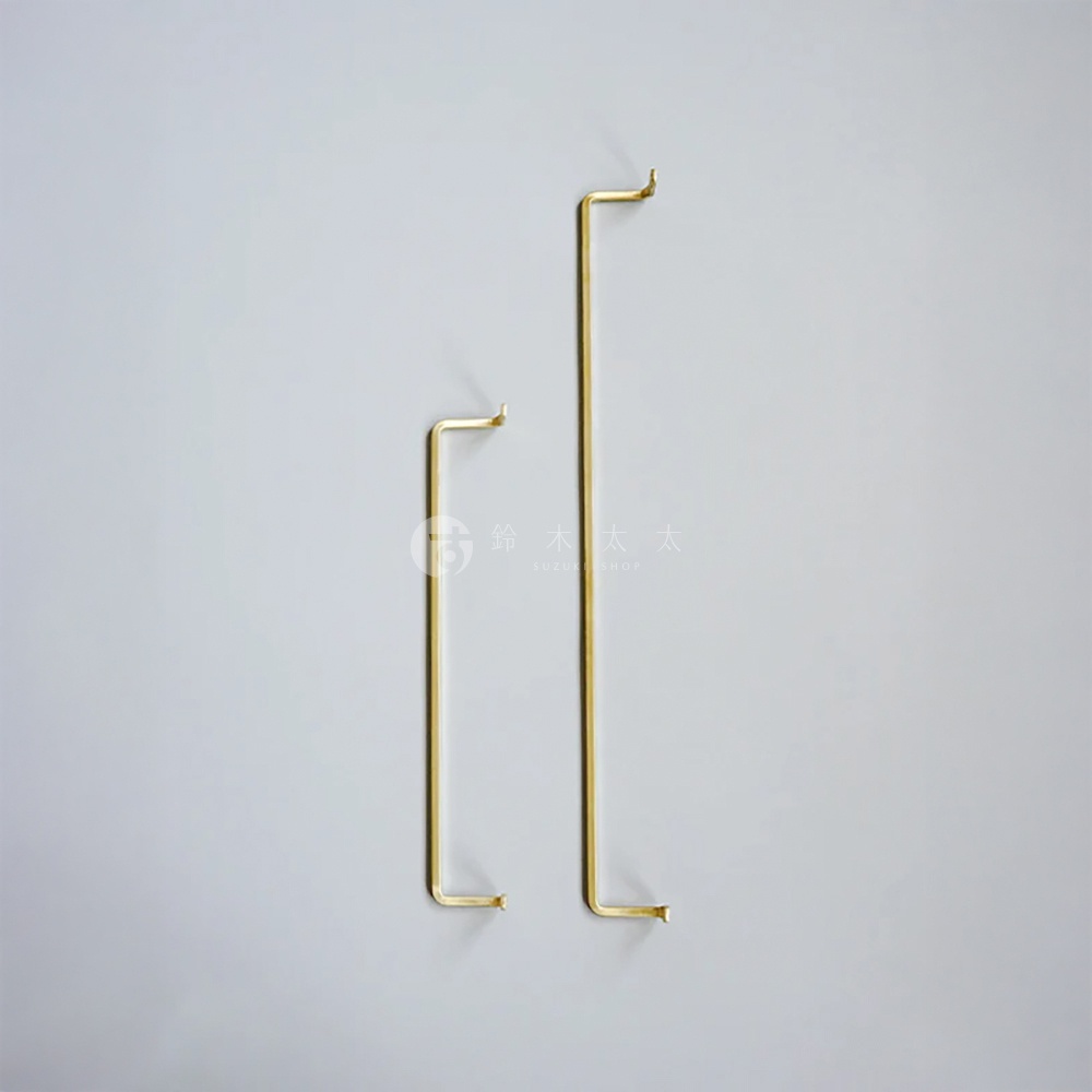 AXCIS 品牌黃銅單桿毛巾架，簡約設計，一長一短兩個，置於淺灰色牆面上，左邊是較短的掛架，右邊是較長的掛架。