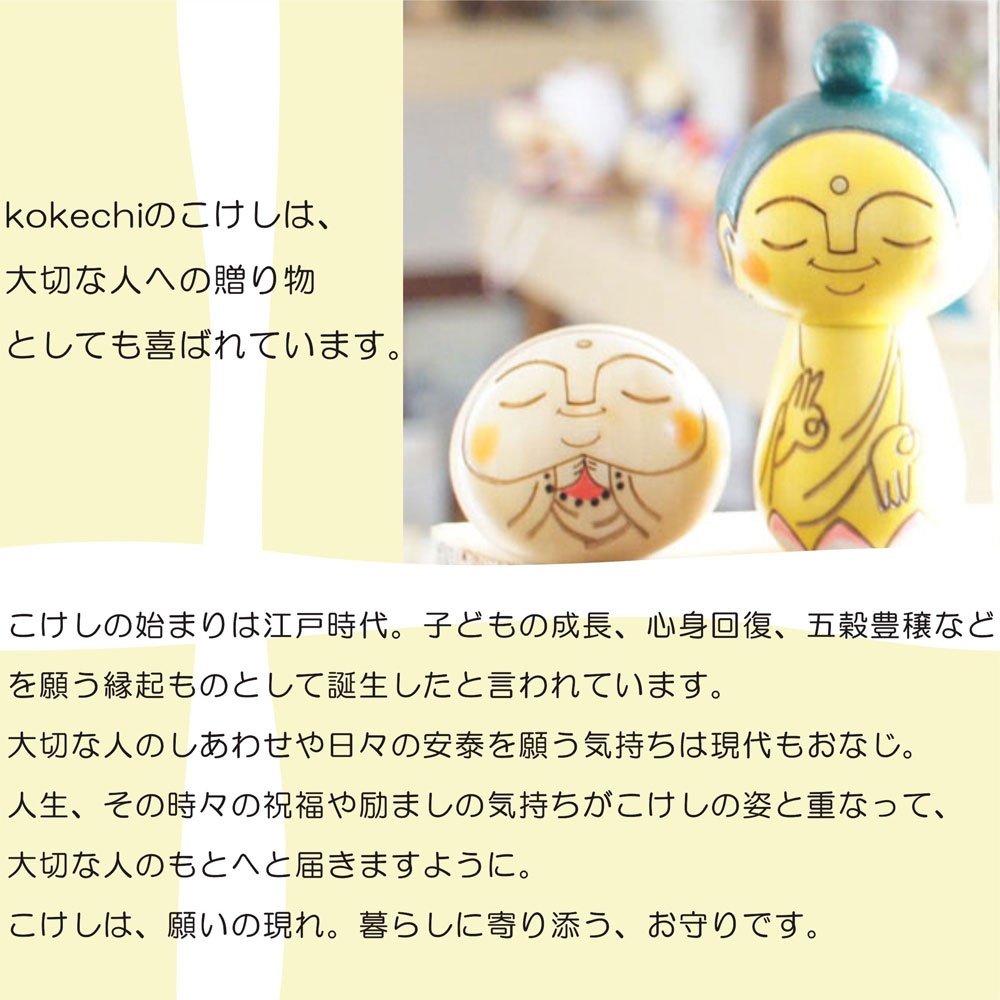 一組木芥子開運擺飾，包含一個圓形、臉部有微笑表情的木芥子，以及一個黃色身體、藍色頭飾、手勢為佛陀印的木芥子。