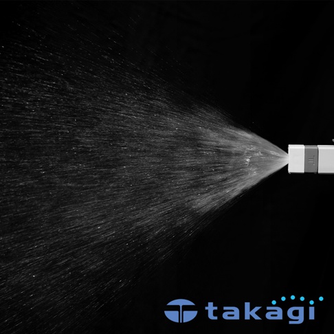 白色與淺灰色塑膠材質的園藝水槍，正以扇形噴灑出細緻的水霧，黑色背景突顯水流動態。