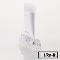 透明壓克力材質的手動轉轉擠牙膏夾，夾著一管白色牙膏，牙膏上有日文標示。