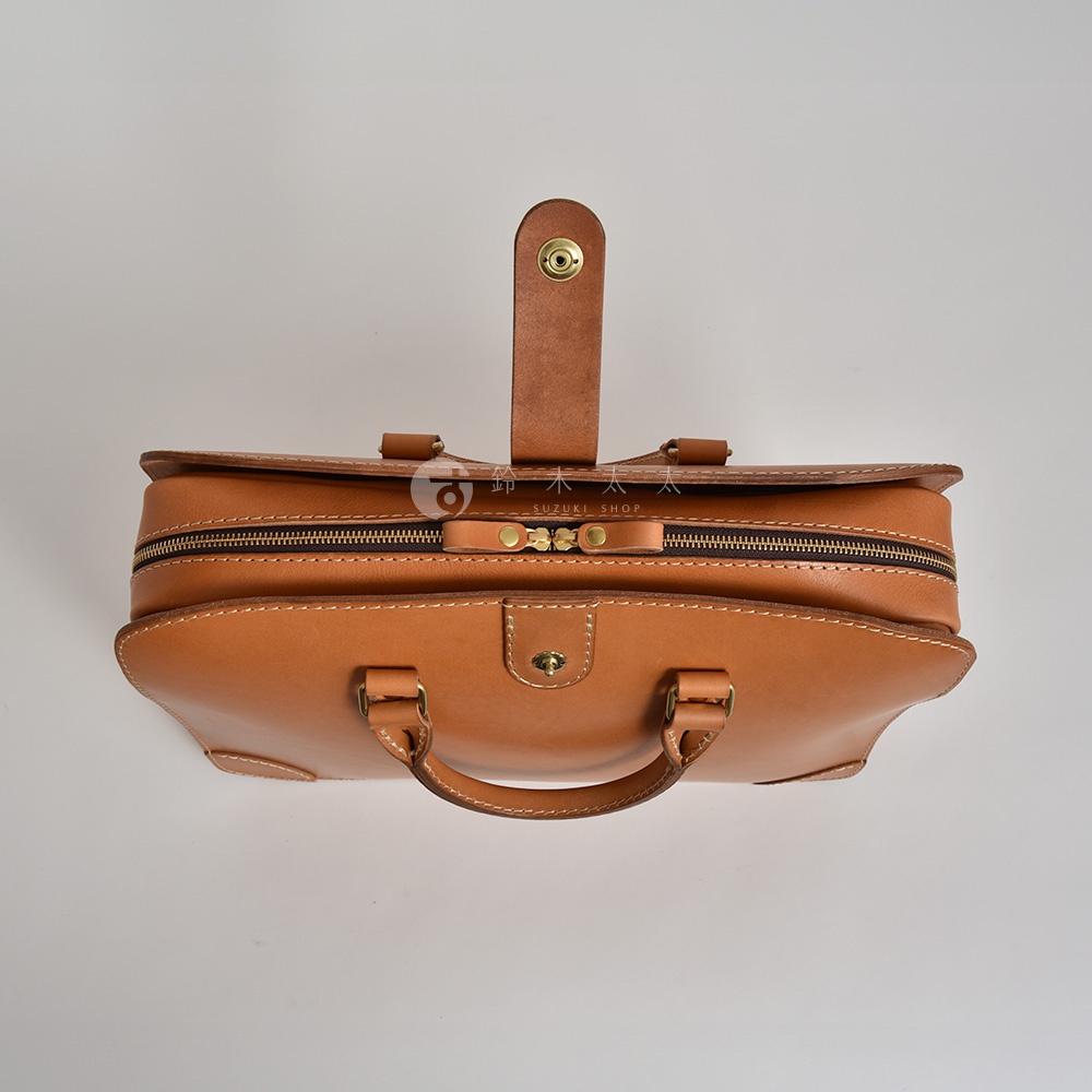 職人手作皮革三層收納兩用商務公事包，採用淺棕色皮革，設有拉鍊開合、兩個提把和一個可釦式皮蓋。