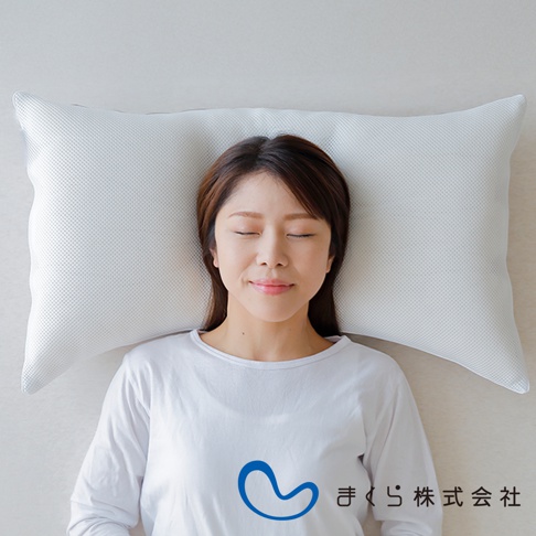 一位女性仰躺在一個白色網狀織物枕頭上，枕頭邊緣有細小的網格紋理。