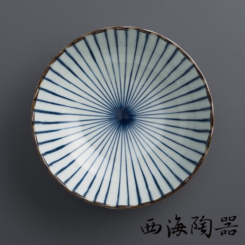 一個波佐見燒兩件式丼飯碗，碗身為白色陶瓷，內側繪有放射狀的藍色線條，中心為深藍色圓點，碗緣有褐色邊飾。