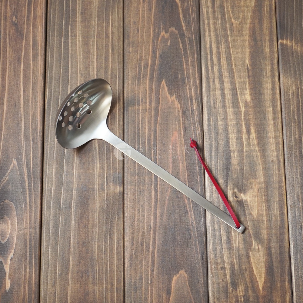 不鏽鋼萬用瀝水湯勺，勺頭帶有多個圓形濾孔，勺柄末端有紅色掛繩。