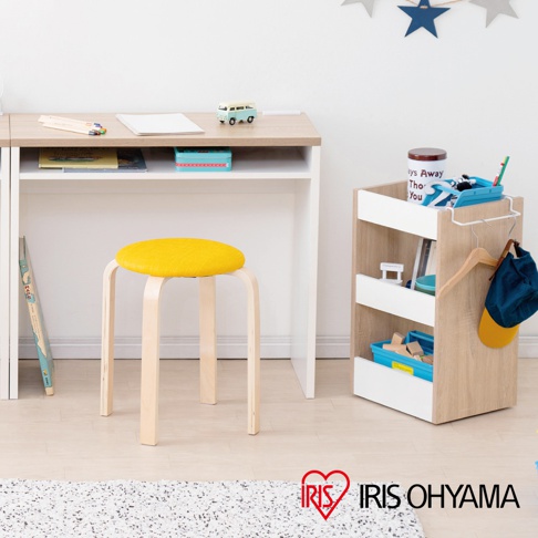 展示一個木質可移動置物櫃，帶有滾輪，木紋飾面，白色隔板，上面放著藍色收納盒、書籍和罐子，右側掛著藍色帽子。