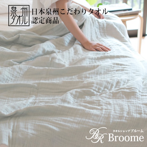 泉州SASARA四層紗輕盈快眠毛巾毯，淺藍色，柔軟親膚的四層紗材質，蓋在床上，一位女性的手輕撫著毛巾毯。