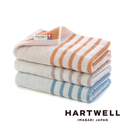三條今治迷你浴巾疊放，頂部為橙色條紋，中間為灰色條紋，底部為藍色條紋。浴巾為純棉材質，觸感柔軟，具有良好的吸水性。
