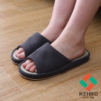 深灰色藺草透氣室內拖鞋，露出腳趾，鞋面為織布材質，鞋墊為藺草編織，鞋底為淺棕色，展現舒適的居家穿著感。