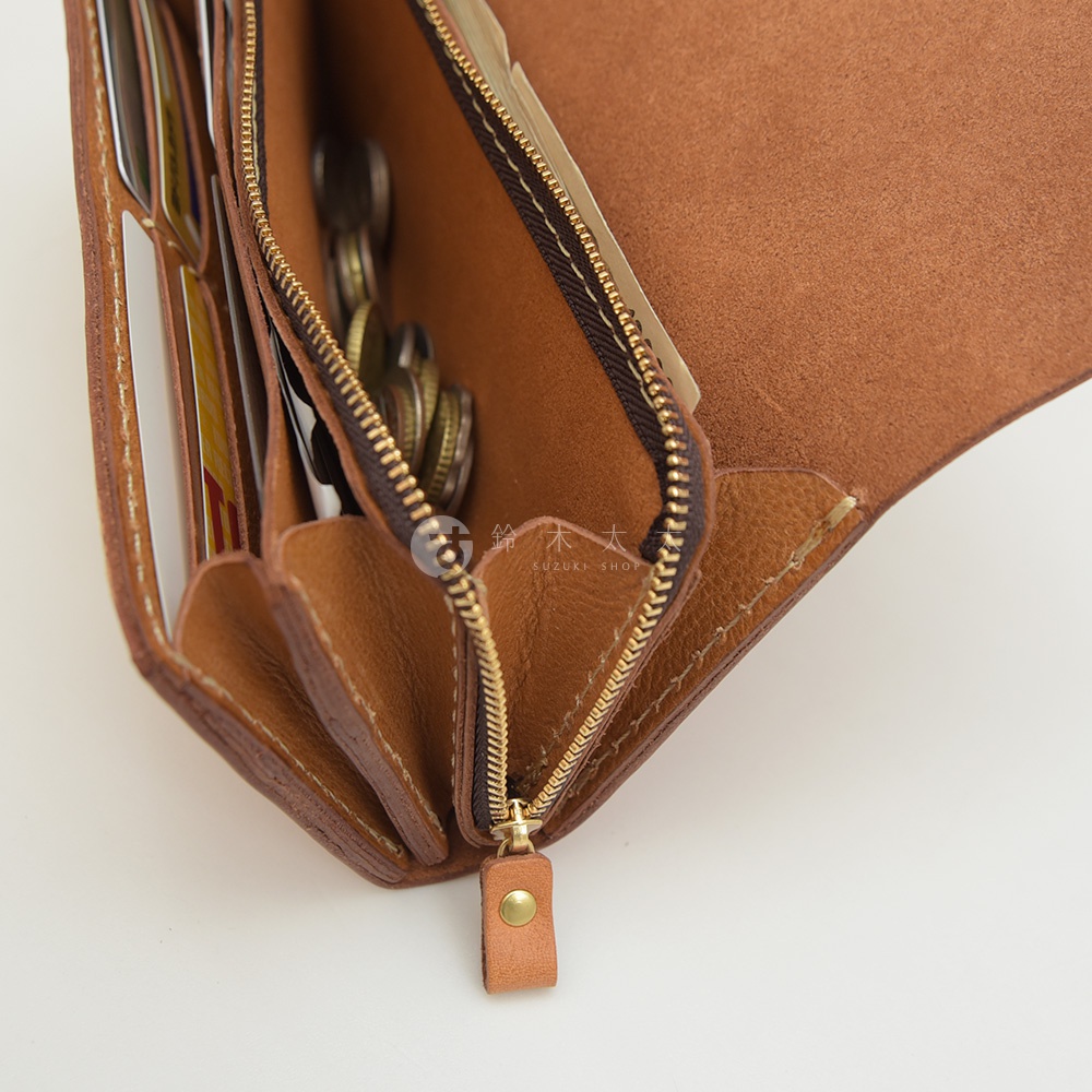 職人手作皮革長夾，焦糖棕色，手風琴式多卡層設計，內部可見多張卡片及零錢，採用金屬拉鍊與皮革拉環。