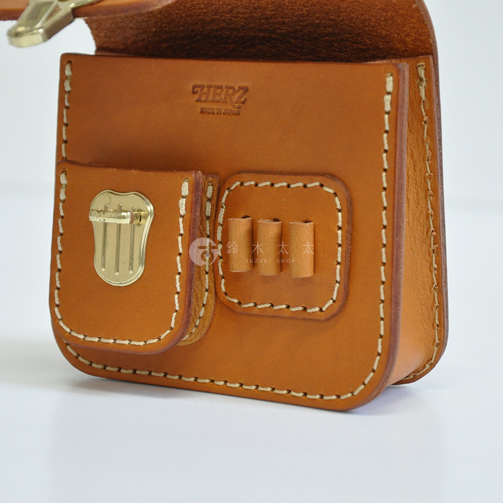 職人手作皮革高爾夫腰包，淺棕色，設有兩個前袋，其中一個袋上飾有金色金屬鎖扣，另一袋有三個皮革彈藥固定環，縫線清晰，材質為天然皮革。