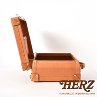 職人手作皮革英倫風便攜手提行李箱 TR-1，呈現淺棕色皮革，箱蓋開啟，露出內部空間，箱邊有金屬鉚釘裝飾，提把位於箱體右側，背景為純白色。