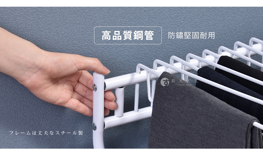 白色金屬材質的多層褲架，展示了其鋼管結構，並掛有多件深色褲子，包括灰色和黑色，展現了耐用性與收納功能。