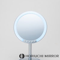 銀色金屬材質的圓形化妝鏡，鏡面周圍有環狀LED燈，下方設有四個圓形按鈕。