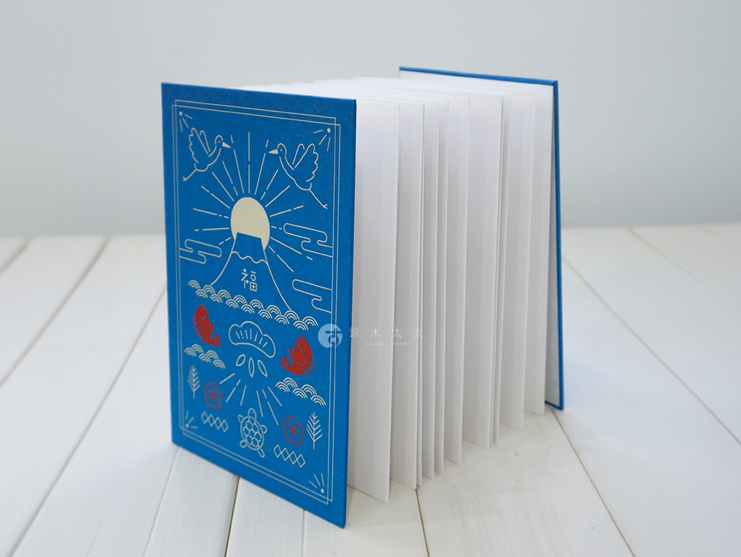 藍色和紙製成的御朱印帳，封面印有富士山、旭日、鶴、鯉魚、龜、松葉等吉祥圖案，線條為白色。