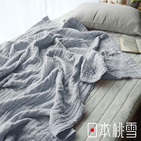 日式風格的淺灰色五層紗單人被，鋪在床鋪上，一旁有枕頭和一本打開的書，右下角有「日本桃雪」的 Logo。
