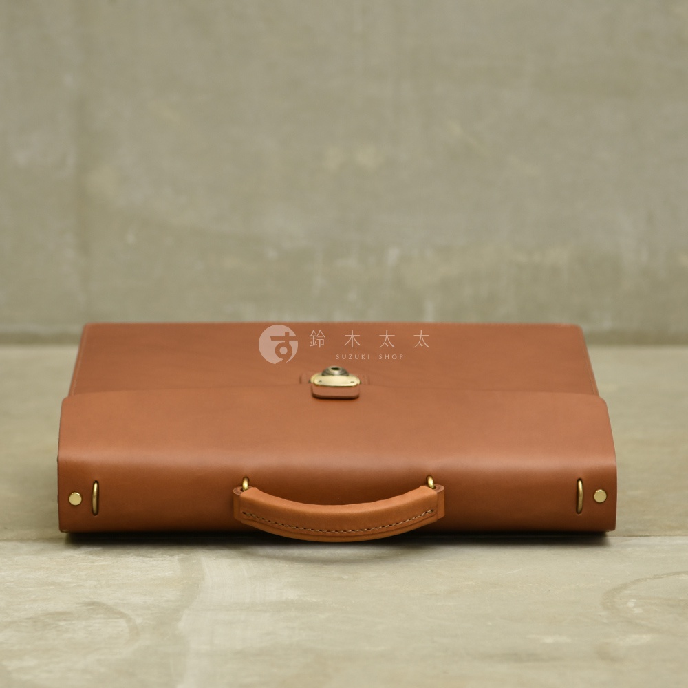 淺棕色皮革製成的兩用公事包，有手柄和金屬釦。