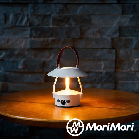 白色 LED 復古燈籠，配有棕色皮革提把，頂部為傘狀燈罩，底部有開關和「AUTO」標誌，置於木桌上，散發溫暖光芒。