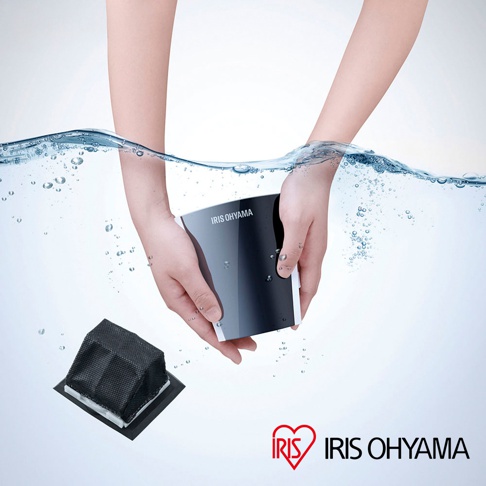 IRIS OHYAMA 品牌標誌旁，雙手正將帶有 IRIS OHYAMA 字樣的黑色電子產品浸入水中，旁側還有一個黑色濾網。