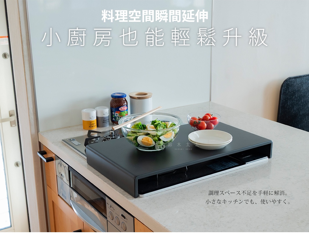 放置在廚房瓦斯爐上的黑色金屬置物架，為小廚房提供額外的調理與置物空間，架上擺放著裝有生菜沙拉的玻璃碗、番茄與空盤，背景為廚房檯面，呈現簡約實用的居家料理環境。圖片上有「料理空間瞬間延伸 小廚房也能輕鬆升級」與日文說明文字。