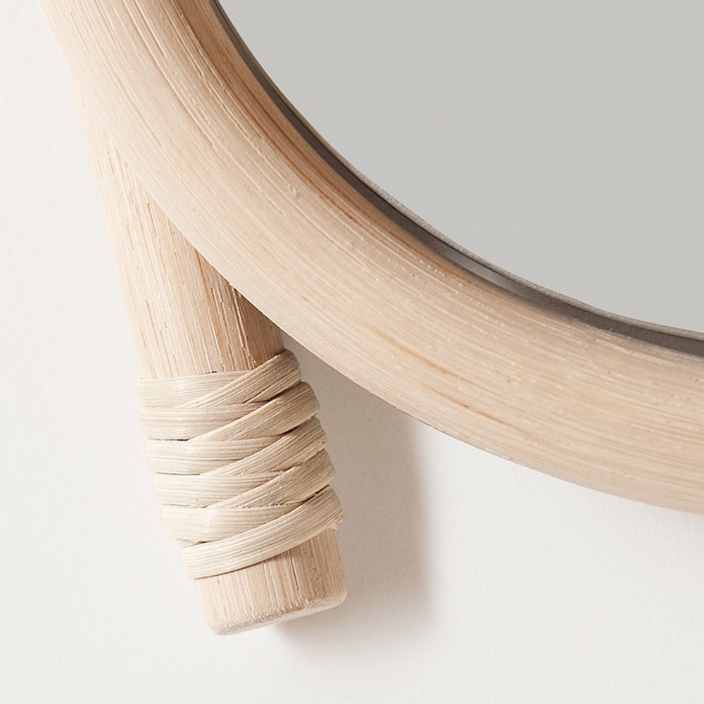 wawa藤編圓鏡，圓形鏡面，邊緣為淺木色藤編框架，其中一側的藤編細節處纏繞著淺色編織繩。