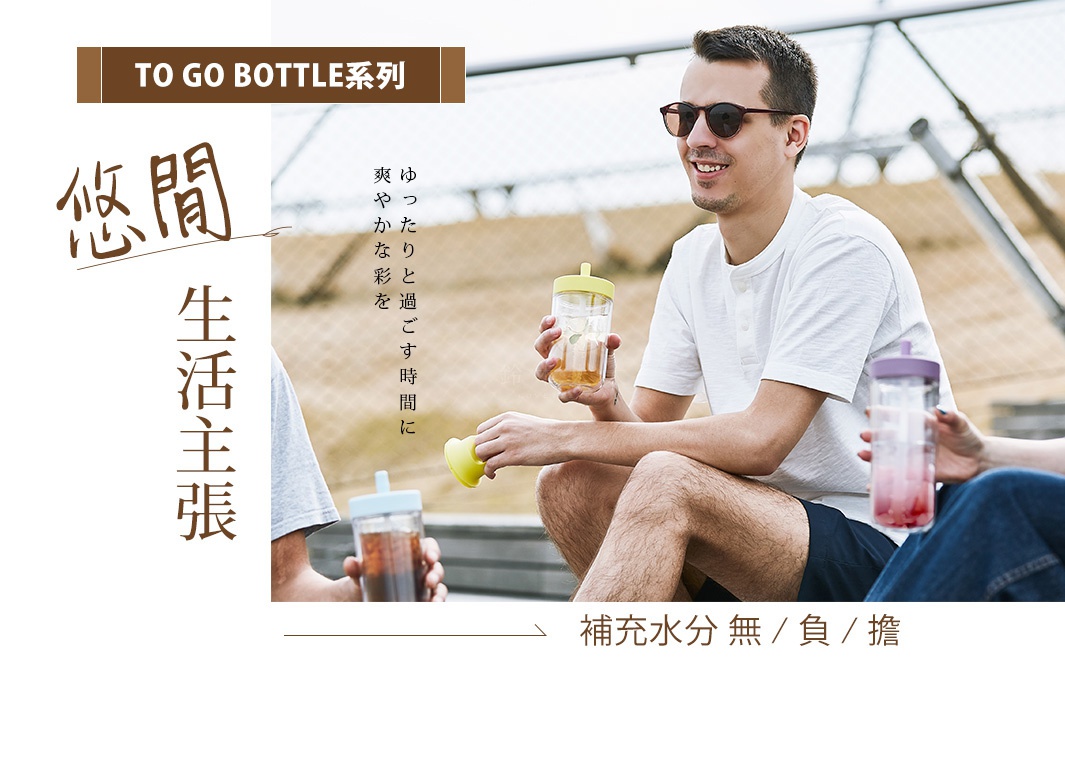 男性手持TO GO BOTTLE雙層隨手瓶，瓶身透明，裝有茶飲，瓶蓋為淺黃色。另一人手中持有相同款式的隨手瓶，瓶蓋為紫色，裝有粉紅色飲品。