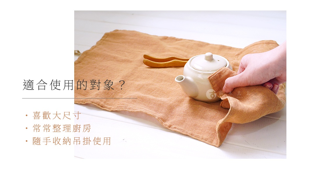 一張橙棕色、三層蚊帳棉織的廚房拭巾，尺寸約為 37x60cm，上面放著一個白色茶壺和兩個木製夾子，一隻手正在擦拭茶壺。