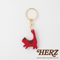 紅色皮革貓咪造型鑰匙圈，搭配咖啡色斑紋，附有金色金屬環及掛鉤。