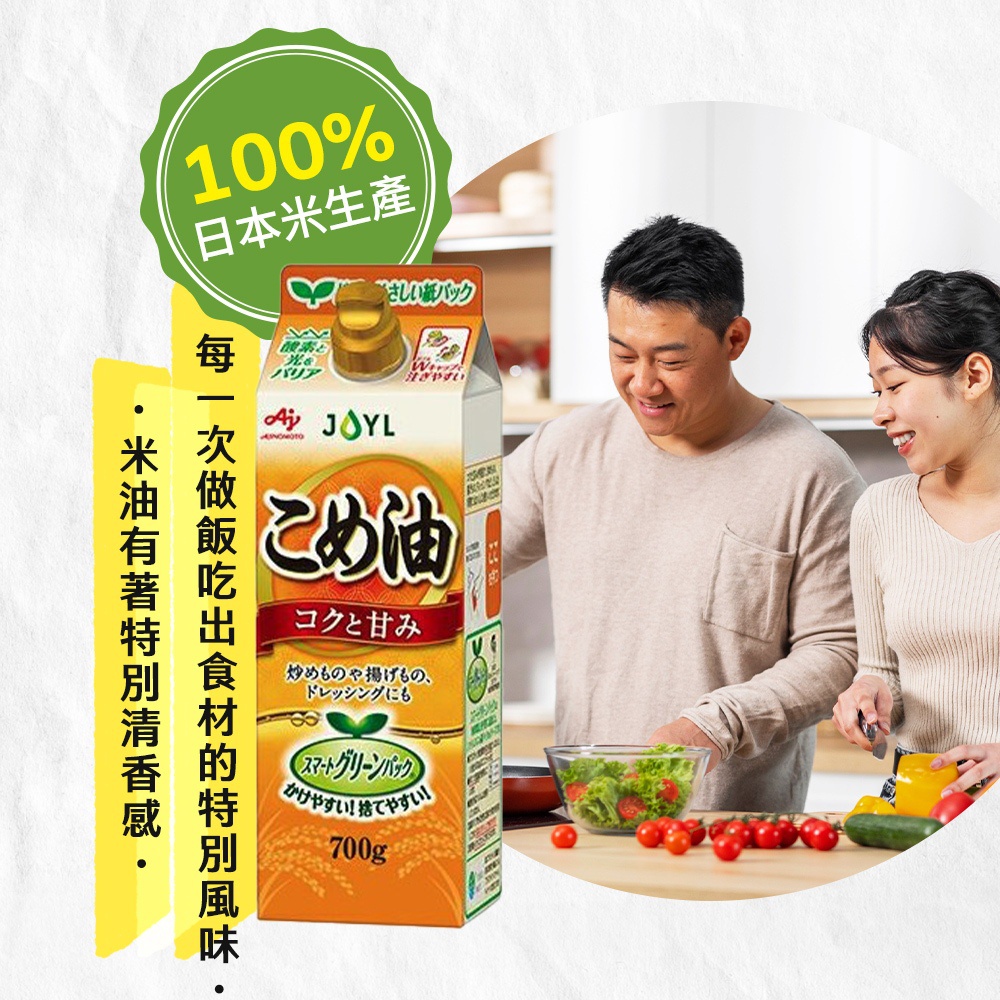 米糠玄米油 (777ml) 紙盒裝，印有日文「こめ油」字樣，主色為橘黃色和白色，側面有綠色葉片與「Smart Green Pack」標誌。背景為一對男女在廚房準備食材的畫面。
