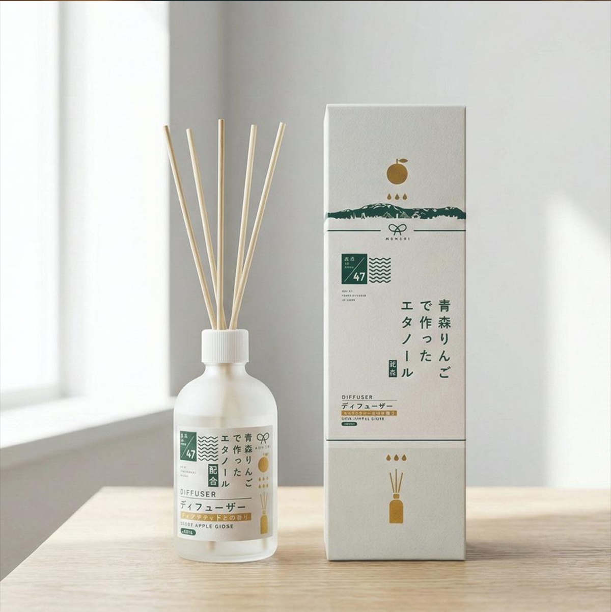 KYARA MUSUBI 室內擴香竹，瓶身與包裝盒上印有日文說明，旁邊擺放著青森蘋果香的擴香竹。