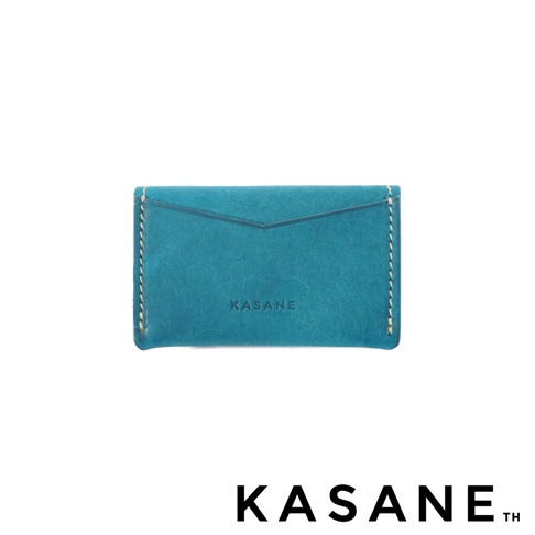 一個藍綠色的皮革名片夾，上面壓印著 KASANE 字樣。