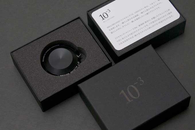 黑色鋁製卷尺2M，置於黑色絨面內襯的包裝盒中，盒蓋上有「10⁻³」字樣。