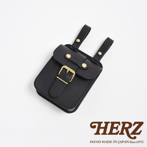 黑色皮革製作的腰袋，附有黃銅釦和皮革繫帶，可固定於腰帶上。