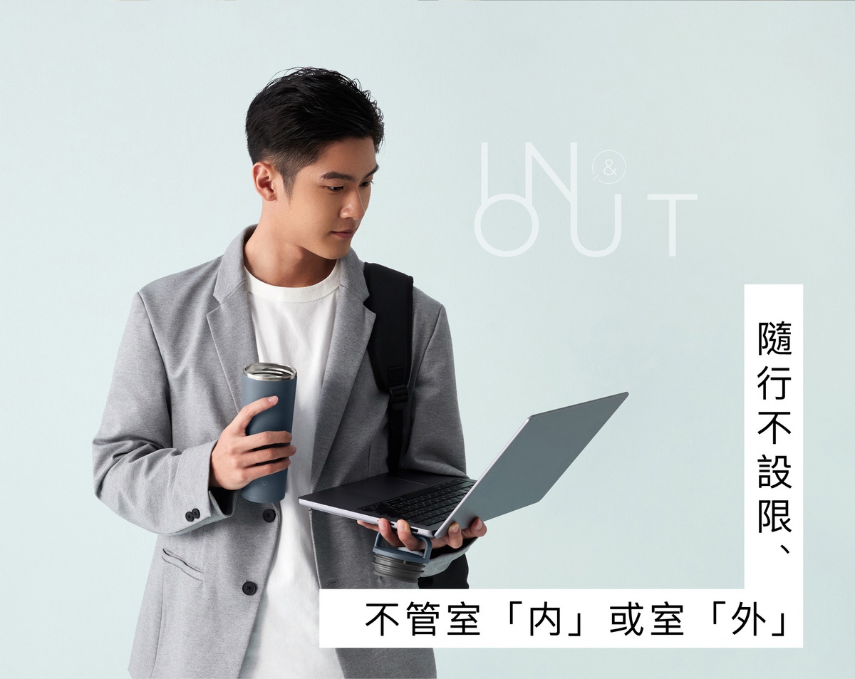 一位身穿灰色西裝外套的男性，手持一個深藍色不鏽鋼保溫杯，搭配筆記型電腦。