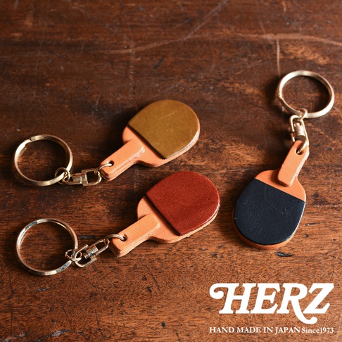 皮革桌球拍造型鑰匙圈，共有三款顏色：黃褐色、紅褐色與黑褐色。以皮革手工製作，搭配金屬鑰匙圈。