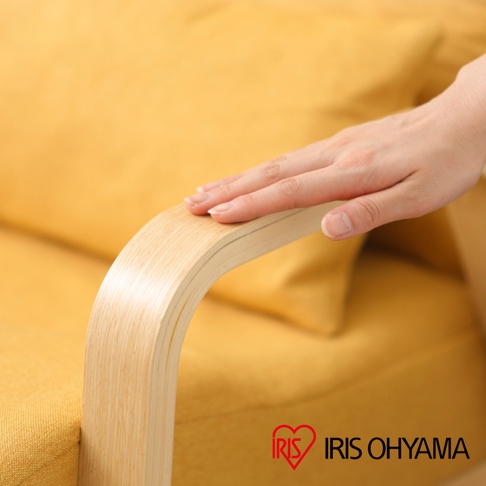 淺黃色布面躺椅，搭配彎曲的淺木色實木扶手，手部輕柔觸碰扶手。