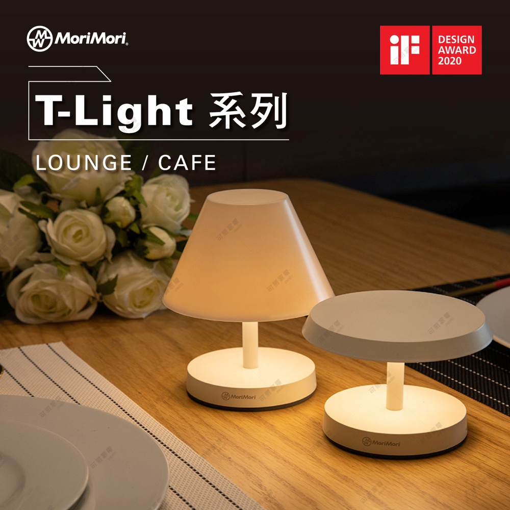 兩盞白色LED T-Light燈，一盞傘型，一盞圓盤型，擺放在木質桌面上，背景有白色玫瑰花束。