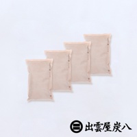 四件淺米色、扁平的調濕木炭包，表面有細密的網格紋路和印製的文字，堆疊擺放於白色背景上。