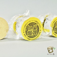 一塊圓形、黃色包裝的天然撫味塊，包裝上有日文文字和圖案。左側還有一塊類似材質的圓形產品。