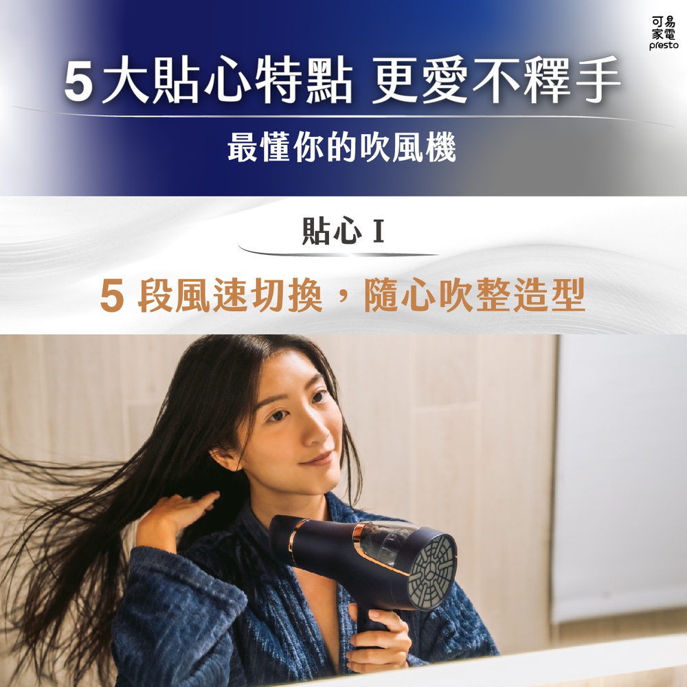 深藍色暴風級雙渦輪負離子吹風機，配有金色飾邊和透明可見風扇，由一位女性使用者於鏡前使用。