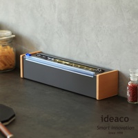 日本製原木鋼製保鮮膜切割器，深灰色鋼製盒體搭配原木色木質邊框，內含保鮮膜，刀刃為透明藍色塑膠蓋保護。