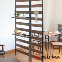 頂天立地收納掛架，深棕色木紋層板與黑色金屬支架，附有兩層置物台，左側層板擺放裝飾品，右側掛有綠植，後方為餐桌椅。