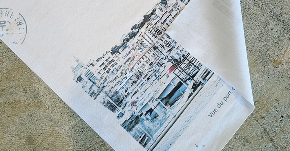 無框帆布藝術海報，印有馬賽港口（Vue du port）的藍白色調風景畫，畫中有建築物、船隻和水景，帆布材質，右上角有部分折疊。
