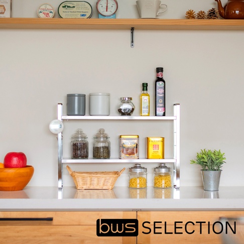 銀色不鏽鋼雙層收納架，展示有灰色和白色罐子、玻璃罐、瓶裝油、調味品罐，以及一個藤編籃子。